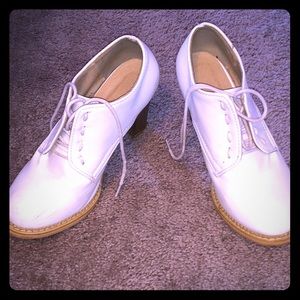 pair of shoes that or white and have a tan bottom